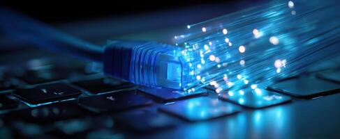 The glowing fiber optic cable connected to a modern keyboard. photo