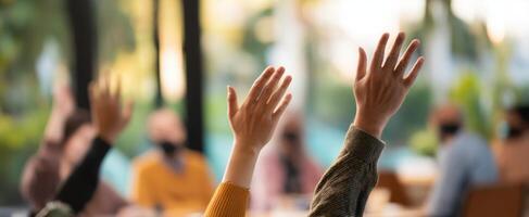 The engaged audience raising hands during an interactive group discussion session. photo