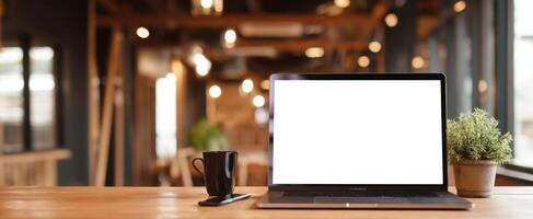 The laptop sitting on a wooden desk in a cozy modern workspace environment. photo