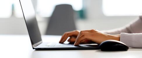 The focused hands typing on a sleek laptop in a bright workspace. photo