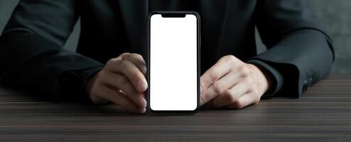 The smartphone held by a businessman on a wooden table background. photo