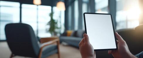 The tablet held in hands against a modern, stylish interior design backdrop. photo