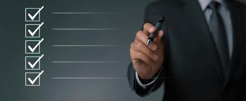 The businessman marking tasks on a checklist for successful completion. photo