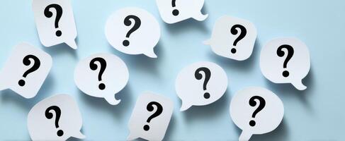 The collection of question mark speech bubbles on a light blue background. photo