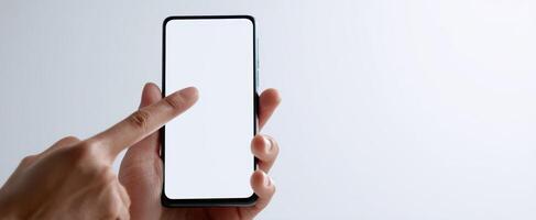 The smartphone held in hand ready for interaction with blank screen photo