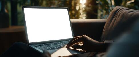 The laptop on a cozy couch illuminated by soft evening light. photo