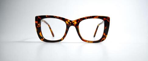 The stylish tortoiseshell glasses on a minimalist background. photo
