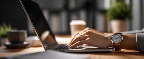 The laptop and stylish watch on a wooden desk during a productive work session. photo