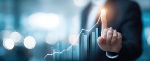 The hand pointing to a glowing financial growth chart in a corporate setting photo