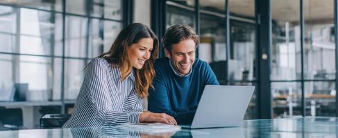 The young professionals collaborating over a laptop in a modern office space. photo