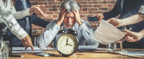 The overwhelmed businessman surrounded by teamwork and pressing deadlines during a meeting. photo