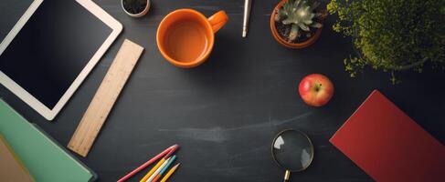 The organized workspace featuring coffee, tablet, and various stationery items. photo