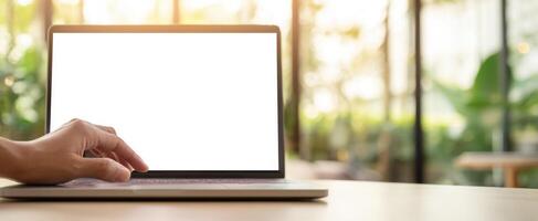 The laptop on a desk with a hand preparing to interact with the screen. photo