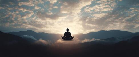 The serene silhouette meditating above clouds at sunrise in tranquil mountains. photo