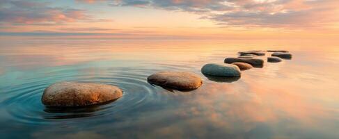 The serene path of stones leading across tranquil water during sunset. photo