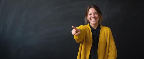 The smiling woman pointing enthusiastically in a classroom setting. photo