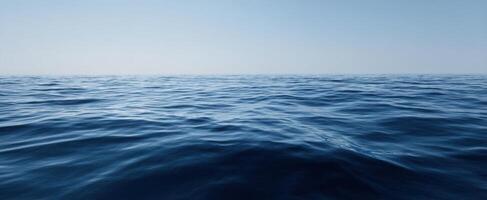 The tranquil ocean waves reflecting the serene blue sky at horizon. photo