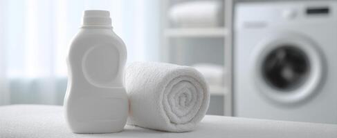The clean laundry setup featuring detergent bottle and fluffy white towel. photo