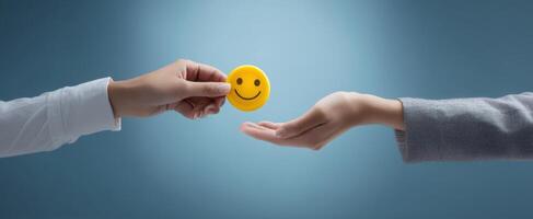 The hands exchanging a smiley face represent connection and positivity in interactions. photo