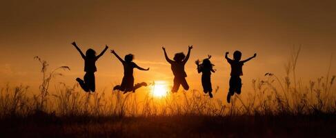 The joyful children leaping together at sunset in a scenic landscape. photo