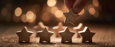 The hand placing a wooden star among a glowing background of soft lights photo