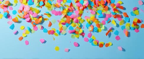 The vibrant confetti scattered across a blue background for festive celebrations. photo