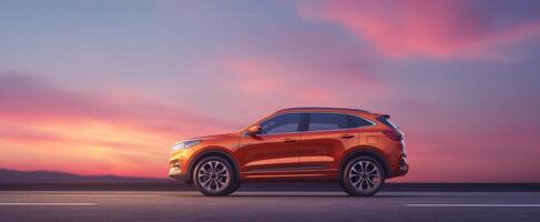 The modern orange SUV against a stunning sunset backdrop on a tranquil road photo