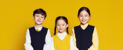 The joyful children posing together against a bright yellow background. photo