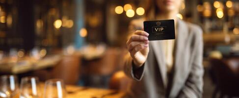 The VIP card held by a woman in an elegant restaurant setting. photo