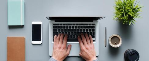 The laptop with hands typing on a modern workspace desk setup. photo