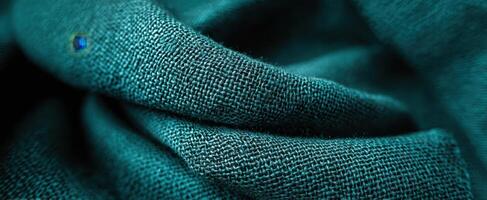 The rich texture of teal fabric showcasing intricate weave and soft drapery. photo