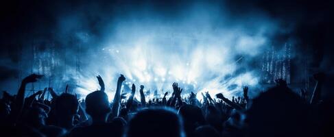 The energetic crowd at a vibrant music festival illuminated by blue lights. photo