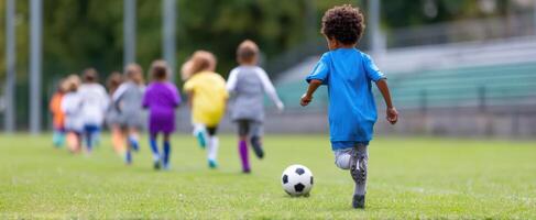 The children playing soccer on a grassy field during a sunny day. photo