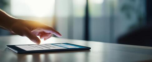 The modern tablet in hand with bright sunlight illuminating the workspace. photo