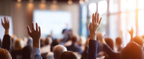 The audience actively participating with raised hands during a seminar. photo