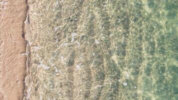 close-up overhead shot of the water of the waves on the shore of a beach on a calm sea day with different focal lengths video