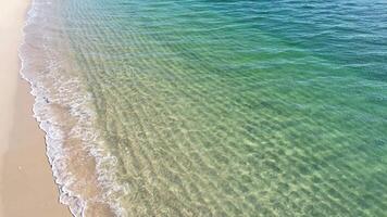 close up drone view footage shot of the water of the waves on the shore of a beach on a calm sea day video