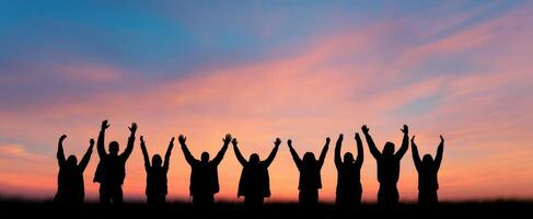 The Joyful Silhouettes Celebrating Together at Sunset photo