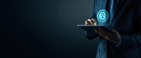 The businessman using a tablet with a security lock icon in a dark background photo