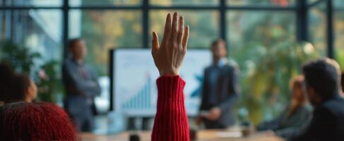 The raised hand in an engaging business meeting showcasing participation and collaboration. photo