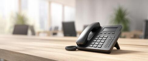 The black telephone on a polished desk in a modern office setting. photo