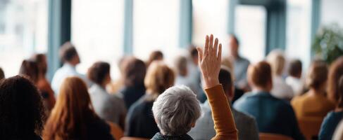 The audience member raising hand during a seminar discussion on engagement. photo