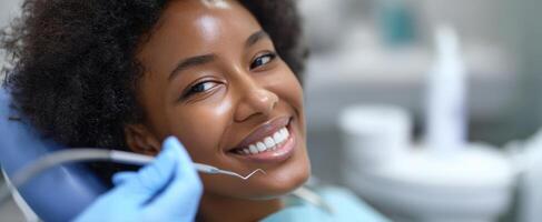 The smiling patient at a dental check-up with a dentist's tool. photo