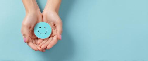 The hands holding a smiling face symbolizing happiness and positivity. photo