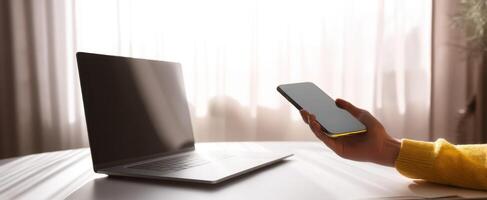 The smartphone and laptop on a modern workspace during a bright morning. photo