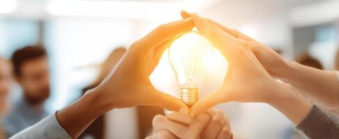 The hands creating a bright idea with a glowing lightbulb in a collaborative setting. photo