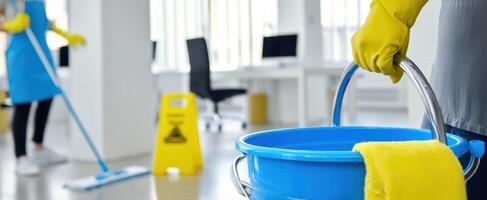 The blue bucket and mop in a bright office space undergoing thorough cleaning. photo