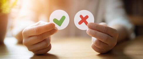 The hands holding green check and red cross mark for choices and decisions photo