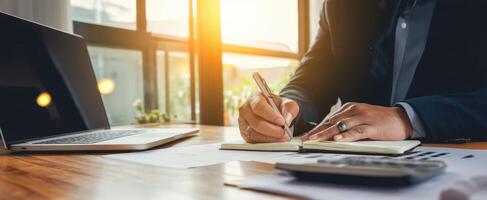 The business professional writing notes at a well-lit office desk. photo