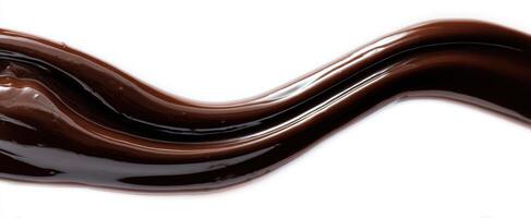 The smooth wave of rich, dark chocolate sauce on a white background photo